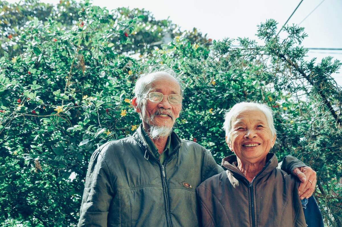 Pareja de personas mayores sonriendo al aire libre